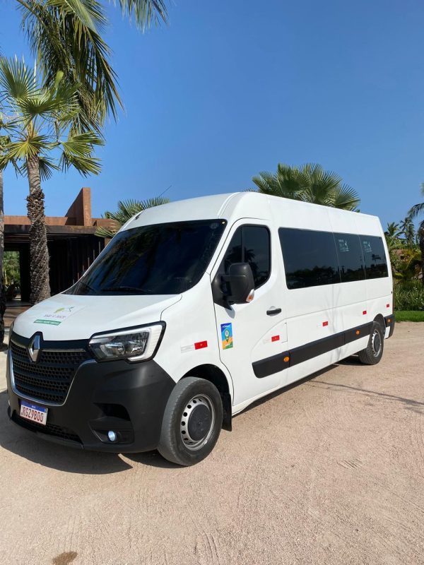 Van confortável e moderna usada no serviço de Transfer Maceió São Miguel dos Milagres, estacionada em frente a um resort tropical.