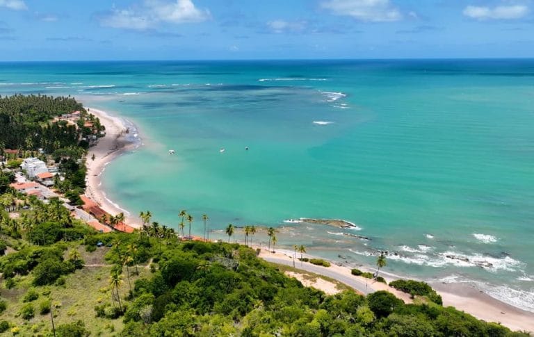 Praia com mar azul-esverdeado em Japaratinga.